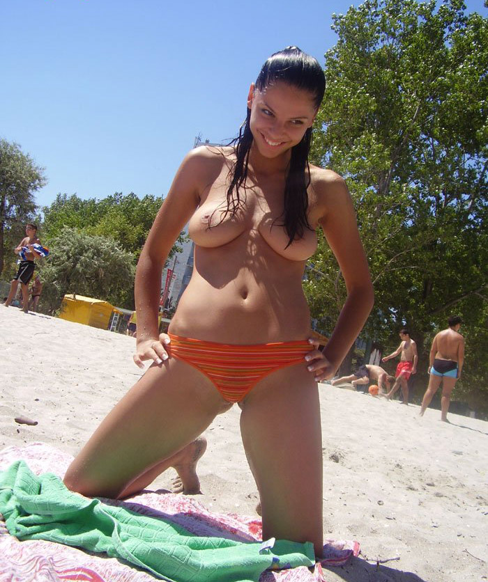 Sexy brunette with big boobs on public beach