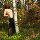 Shy redhead posing topless at forest