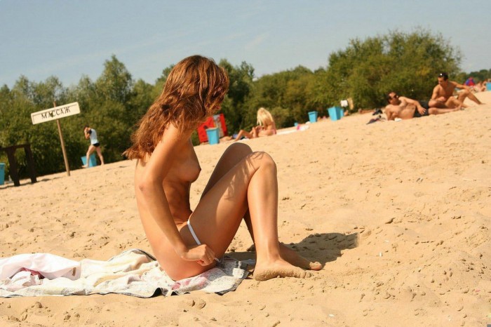 Redhead amateur removes her panties on public beach