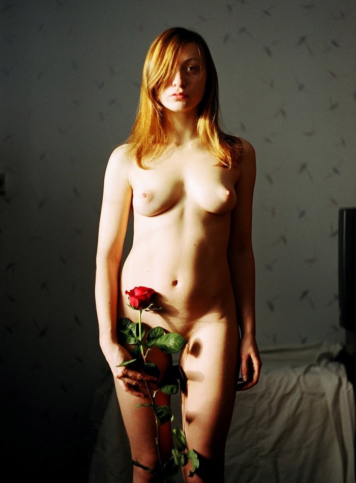 Beautiful redhead hottie stripping naked with a rose in her hand