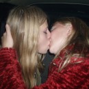 Two young teen blondes kissing in car