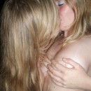 Two young teen blondes kissing in car