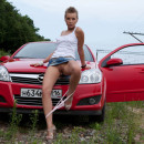 Short-haired russian girl posing naked at public near car