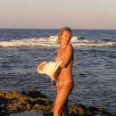 Short-haired blonde posing naked at the sea