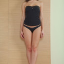 Curly girl with sweet smile undressing