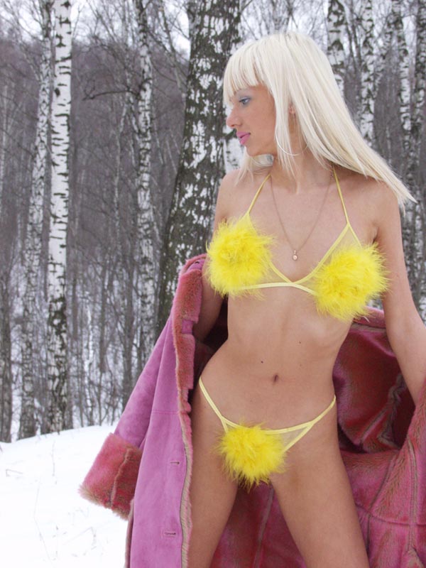 Russian blonde is undressing yellow bikini at winter forest