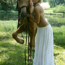 Petite blonde with small tits posing with horse