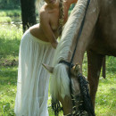Petite blonde with small tits posing with horse