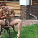 Russian girl with redhead and blue eyes posing with dog outdoors