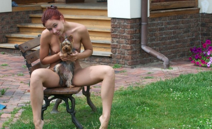 Russian girl with redhead and blue eyes posing with dog outdoors