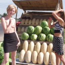 Short-haired blonde undresses at public market outdoors
