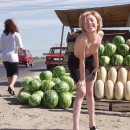 Short-haired blonde undresses at public market outdoors