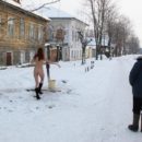 Naked girl collects water in the winter in Russian village