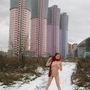 Smiling busty teen wears only red scarf at winter streets