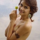 The short-sheared cute girl posing in a river with water lilies