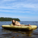 Young girl posing naked on an air mattress outdoors