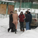 Naked blonde plays snowballs with her friends at winter road