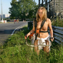 Naked blonde teen mows lawn near public stadium