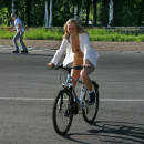 Naked blonde with awesome boobs ride bicycle at public park