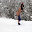 Thin brunette wearing Santa Claus hat in the woods