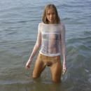 Young angel in very sexy transparent wet dress on the beach