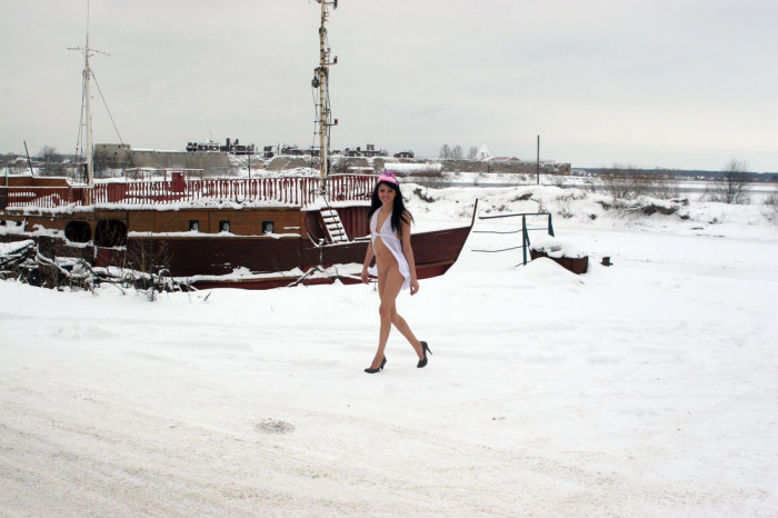 Skinny brunette posing naked at frozen pier