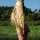 Sporty blonde with really long hair at the lake