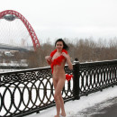 Sporty brunette teen with nice body walks naked at winter bridge