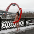 Sporty brunette teen with nice body walks naked at winter bridge
