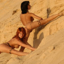 Two russian girls widely spread legs on the sandy shore