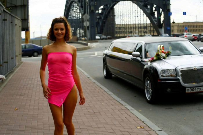 Smiling girl in pink transparent dress in the middle of bridge road
