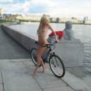 Two naked girl with a bicycle on the promenade road