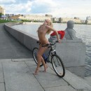 Two naked girl with a bicycle on the promenade road