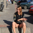 Lovely girl with no panties sitting on the pavement