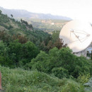 Smiling naked teen near giant radio telescope