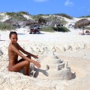 Young girl sunbathing on a nudist beach during vacation