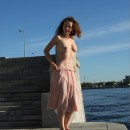 Curly young girl with gorgeous boobs on the pier