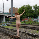 Naked red-haired girl on the train tracks