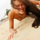 Smiling nudist teen running along the beach