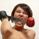 Short-haired girl with nice boobs posing with knife and apple