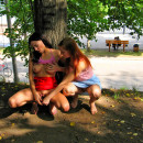 Two naked lesbians playing with dildo at public