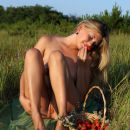 Lady with wonderful bod posing with strawberries in a field