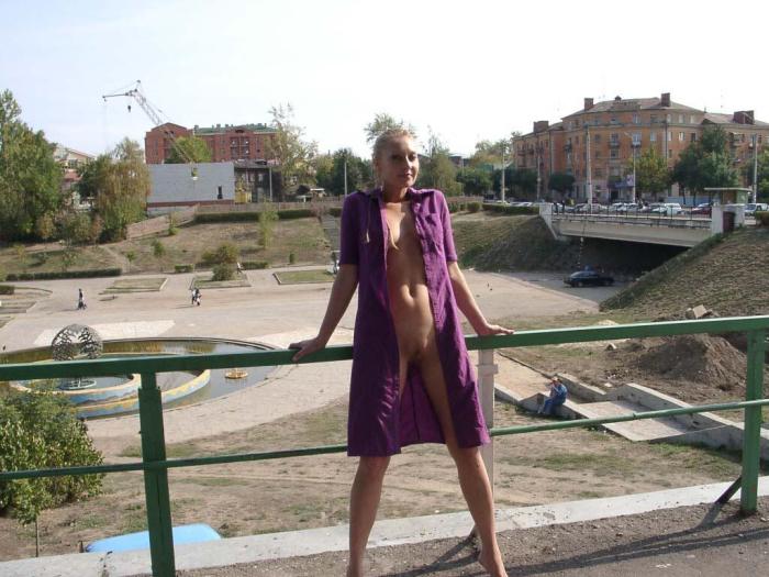 Blonde with dreadlocks walks in the purple coat on public places