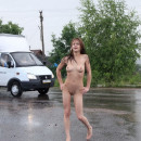 Naked girl on a wet highway