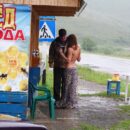 Nude girl buys the honey in the rain