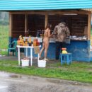 Nude girl buys the honey in the rain