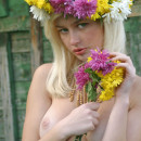 Busty blonde with green eyes posing with flowers