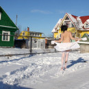 Brunette in white stockings walking at snow-covered village