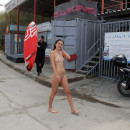 Naked girl on a public pebble beach