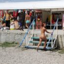 Naked girl selects souvenirs in the resort town
